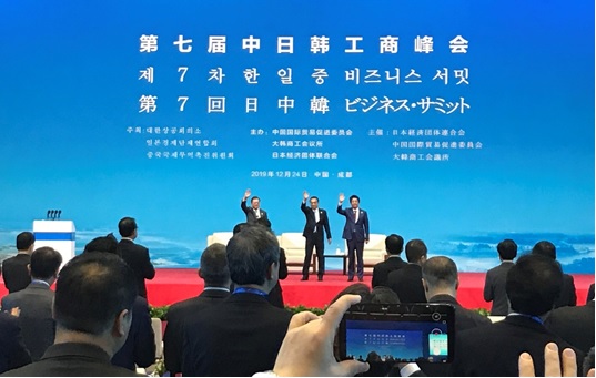 写真　登壇した安倍晋三首相（右）、中国の李克強首相（中央）、韓国の文在寅大統領（左）（ジェトロ撮影）
