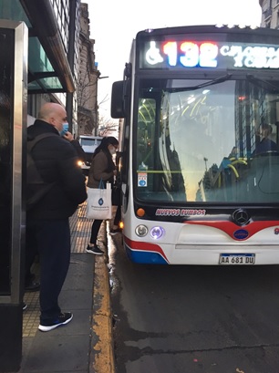 写真　マスクを着用してブエノスアイレス市内を走るバスに乗り込む乗客（ジェトロ撮影）