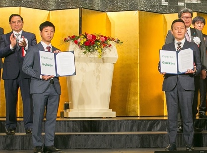 写真　日越投資カンファレンスでチン首相、萩生田大臣を前に覚書を披露する学研（右）とキディハブ（左）の代表者（ジェトロ撮影）
